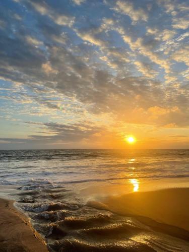 a sunset on a beach with the ocean at Un Dia Boutique Resort in Playas