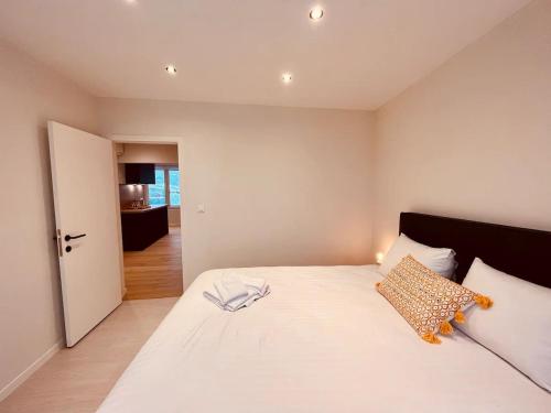 Schlafzimmer mit einem großen weißen Bett und einer Tür in der Unterkunft Cosy Of John Cockerill in Seraing