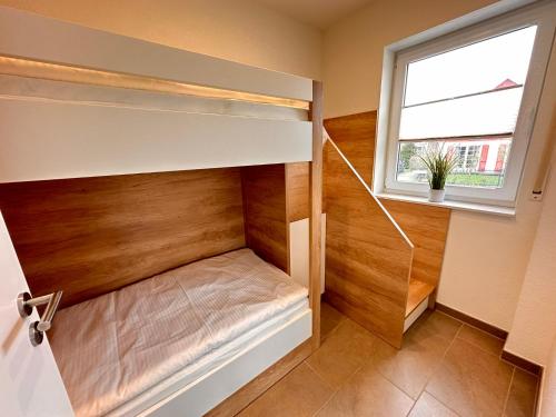 a room with a bunk bed with a window at Haus Hobbingshof Greetsiel in Greetsiel