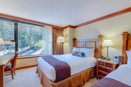 1 dormitorio con 2 camas, escritorio y ventana en Resort at Squaw Creek's 605, en Olympic Valley