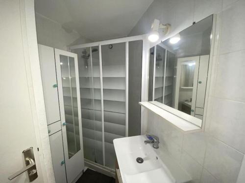 Un baño blanco con lavabo y espejo. en L'appartement des Albères, en Laroque-des-Albères