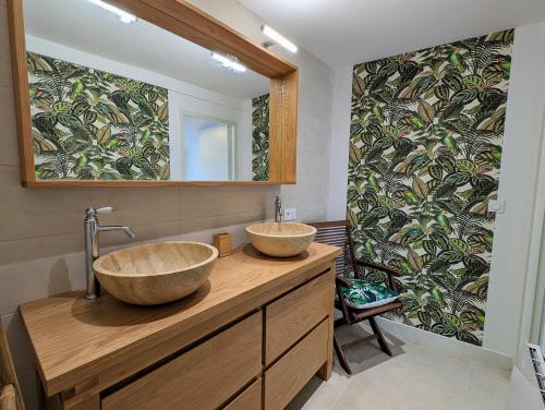 two sinks on a wooden counter in a bathroom at Charmante Maison au centre-ville in Pornic