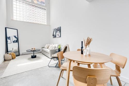 a living room with a table and chairs at Le Mile End by M11 - Modern Luxe 1BDR with Sofa Bed in Montréal