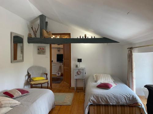 - une chambre avec 2 lits et une étagère sur le mur dans l'établissement Chambres à la campagne, à Sauveterre