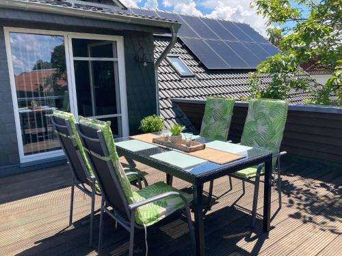 a table and chairs on a deck with solar panels at Schöne Aussicht - b45799 in Wienhausen