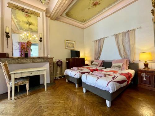 a bedroom with two beds and a table and a fireplace at Côté Cité appartements - Parking privé - 100m Cité médiévale in Carcassonne