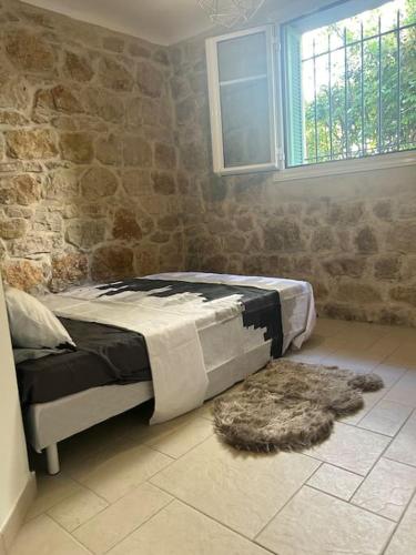une chambre avec un lit et un mur en pierre dans l'établissement T3 dans une villa près de la mer, à Nice