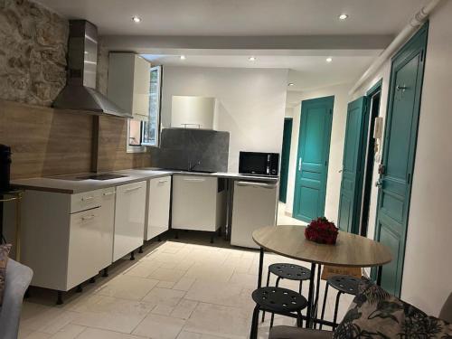 - une cuisine avec une table, une petite table et des chaises dans l'établissement T3 dans une villa près de la mer, à Nice