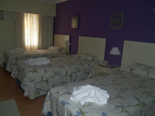 سرير أو أسرّة في غرفة في HOTEL LOS TILOS RECONQUISTA