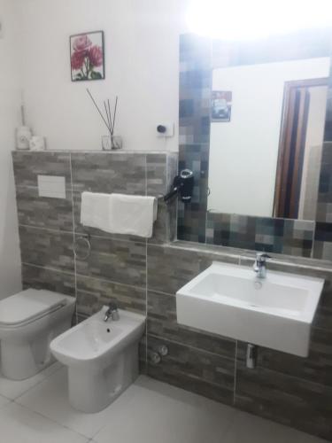a bathroom with a sink and a toilet and a mirror at Affittacamere da chris in Reggio Calabria