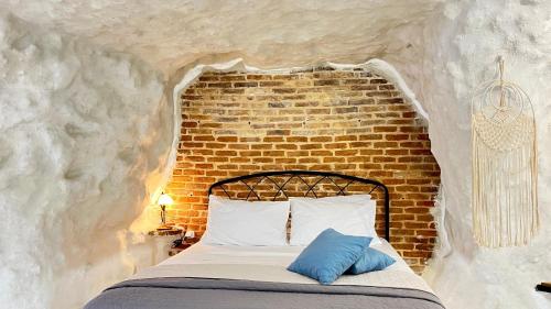 a bed in a room with a brick wall at Cave house in Heraklio Town