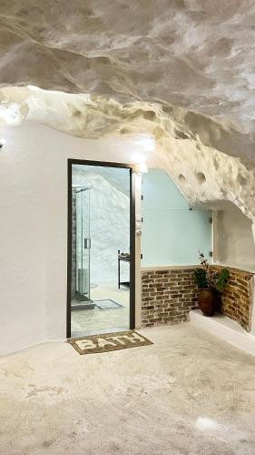 a room with a large glass door and a stone wall at Cave house in Heraklio Town