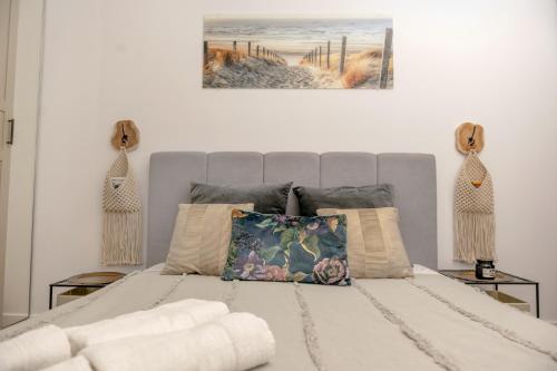 um quarto branco com uma cama com um quadro na parede em Porta Mare Dziwnów Zacisze Resort & Spa em Dziwnów
