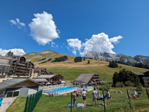 a group of people standing in the grass near a pool at Combe Blanche 1217 in Manigod