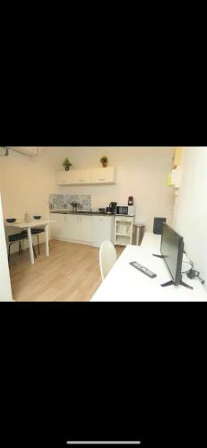 une pièce avec un bureau avec un ordinateur et une cuisine dans l'établissement Studio Cosy Proche Centre Ville, à Villeurbanne