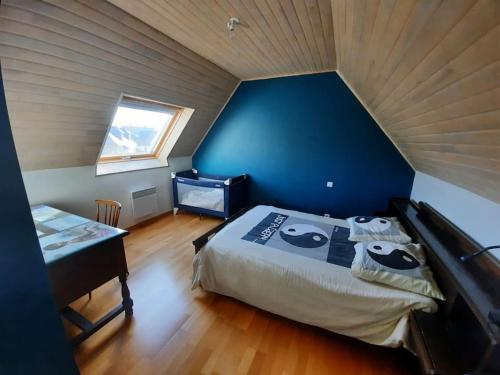 une chambre avec un grand lit avec un mur bleu dans l'établissement Ty Beg Meil, à Fouesnant