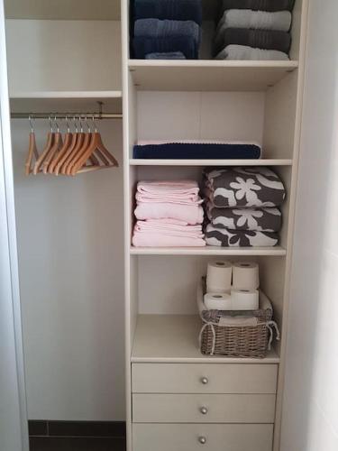 - un dressing avec des placards blancs et des serviettes dans l'établissement Cosy&Charme piscine chauffée Bassin d'Arcachon, à La Teste-de-Buch