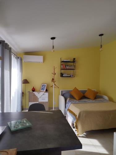 une chambre avec un lit, un bureau et une table dans l'établissement Bienvenue au Dormidou en Provence !, à Vacqueyras