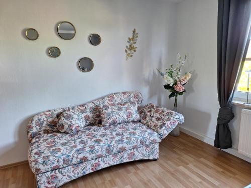 a living room with a couch and a vase of flowers at Schöne Maisonettewohnung in der Barlachstadt Güstrow in Güstrow