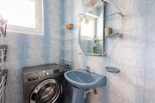 y baño con lavadora y lavamanos. en BALATON A KERTBEN - Csodálatos panorámával rendelkező, közvetlen vízparti apartmanok, en Balatonfenyves