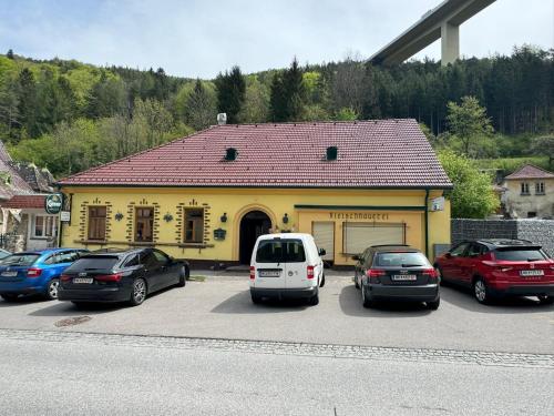 a yellow building with cars parked in a parking lot at Schöne Ferienwohnung in Schottwien
