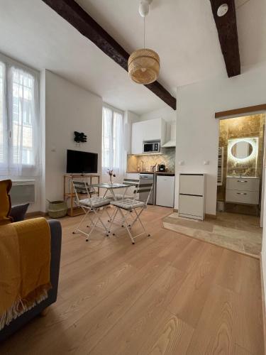 un salon avec une table et des chaises et une cuisine dans l'établissement Cosy et central - Cours Julien, à Marseille
