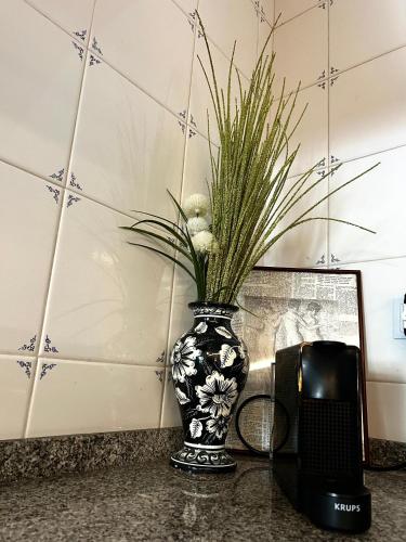 a black and white vase with a plant in it at D'Oliva Gerês - River Side Houses in Geres