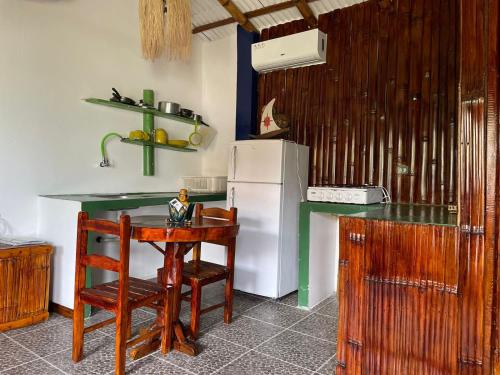 a kitchen with a table and a refrigerator at Un Dia Boutique Resort in Playas
