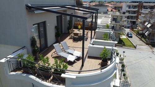 balkon z krzesłami i stołami w budynku w obiekcie Irida Apartments w mieście Leptokaria