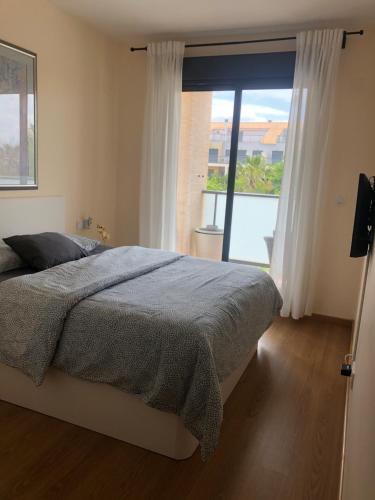 - une chambre avec un lit et une grande fenêtre dans l'établissement Apartment Panoramica Golf, à Sant Jordi