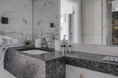 Un baño con lavabo y un espejo grande. en Apartament Nadmorski Luksus - Boulevard, en Ustronie Morskie