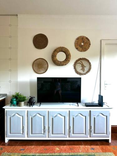 a white entertainment center with a flat screen tv on a wall at D'Oliva Gerês - River Side Houses in Geres