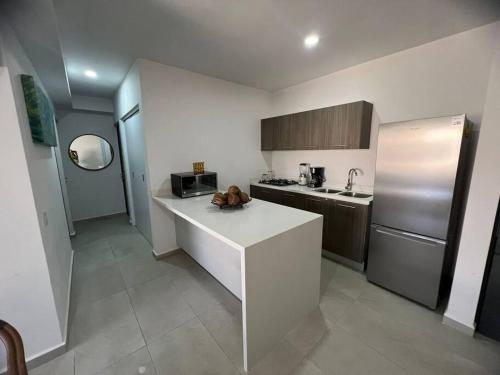 Una cocina con encimera blanca y refrigerador. en Best option in Mazatlan, en Mazatlán