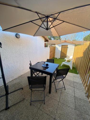 - une table et des chaises sous un parasol sur la terrasse dans l'établissement Bienvenue Chez Timta, à Arès