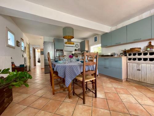 une cuisine avec une table et des chaises dans une pièce dans l'établissement Maison Bocage - lumineuse avec jardin, à Carcassonne