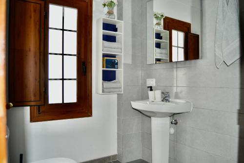 a bathroom with a sink and a toilet and mirrors at Apartamento Eli Beach Tenerife in Candelaria