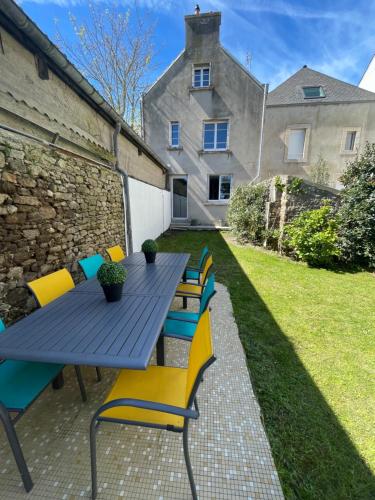 a blue table and chairs with a house in the background at Maison 4 chambres in Saint-Pol-de-Léon
