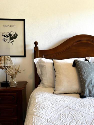 a bedroom with a bed with a wooden headboard and pillows at D'Oliva Gerês - River Side Houses in Geres