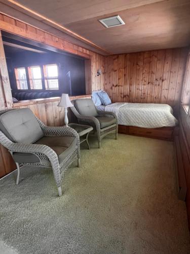 a room with two beds and two chairs and a bed at The Hygge Hideaway in Carp Lake