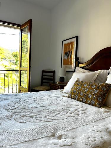 a bedroom with a large white bed with a window at D'Oliva Gerês - River Side Houses in Geres