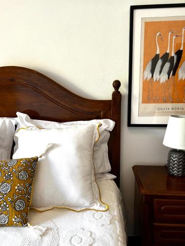 a bedroom with a bed with a wooden headboard and pillows at D'Oliva Gerês - River Side Houses in Geres