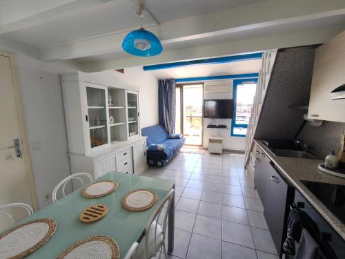 a kitchen and living room with a table and chairs at Appartement Port Barcarès Vue Marina in Le Barcarès