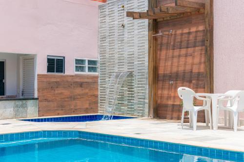 a patio with a table and chairs next to a pool at Pousada Meia Lua in Pirenópolis