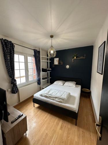une chambre avec un lit et un mur bleu dans l'établissement Appartement Citadelle 2, à Dunkerque
