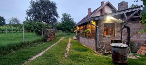 Farmica Bed&Breakfast في Ðurđevac: منزل من الطوب وامامه سلة مهملات