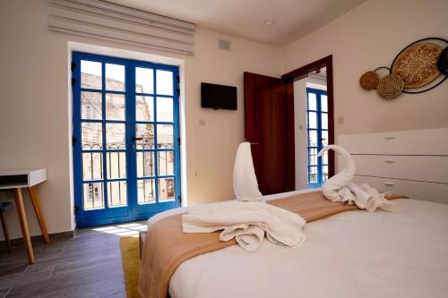a bedroom with a bed with towels on it at Mosta Dome Penthouse in Mosta