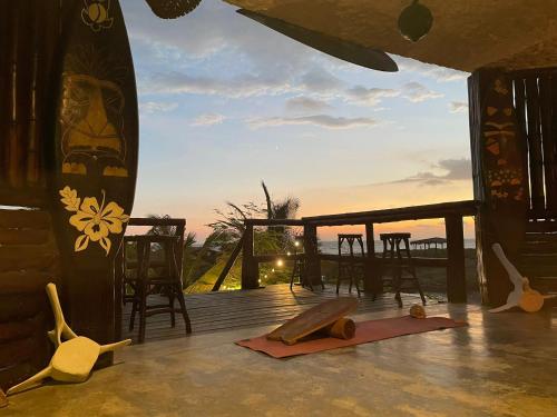 a deck with a table and some surfboards on it at Un Dia Boutique Resort in Playas