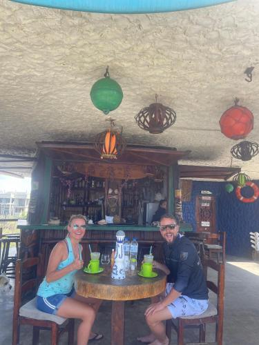 a man and woman sitting at a table in a restaurant at Un Dia Boutique Resort in Playas