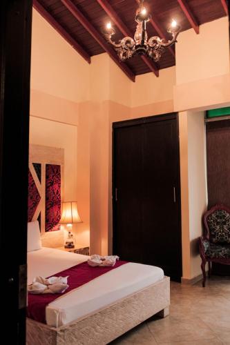 a bedroom with a bed with a black door and a chair at Hotel Plaza Garibaldi in Caldas