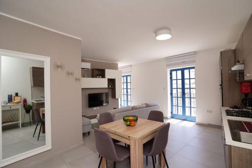 una cucina e un soggiorno con tavolo e sedie di Mosta Dome Penthouse a Mosta